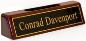 Polished brass name plates with an attractive piano polished wood display base with slot for business cards.