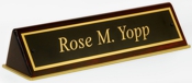 Polished brass name plates with an attractive piano polished wood display base.